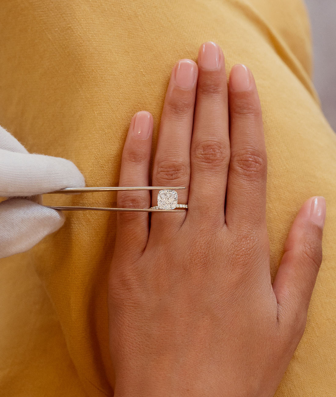 bijoux en diamants naturels sur-mesure réalisés à Paris par Amantys Un Conseiller Gemmologue de la Maison Amantys dépose un diamant naturel sur la main d'une cliente.